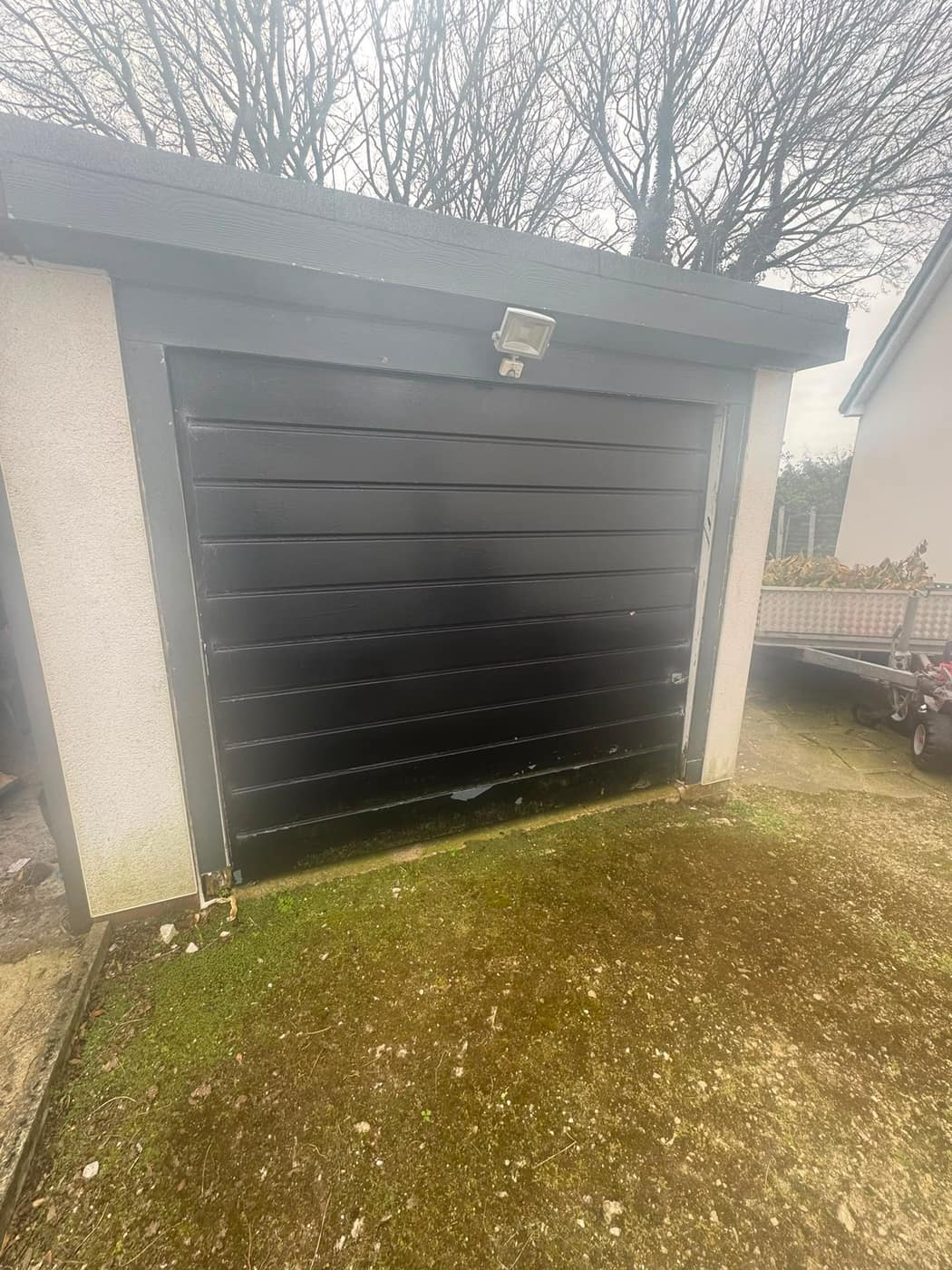 Old weathered black garage door before replacement