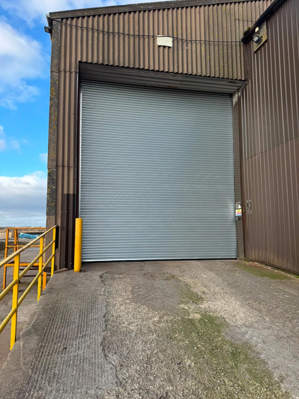 Insulated industrial roller shutter on a steel-clad warehouse