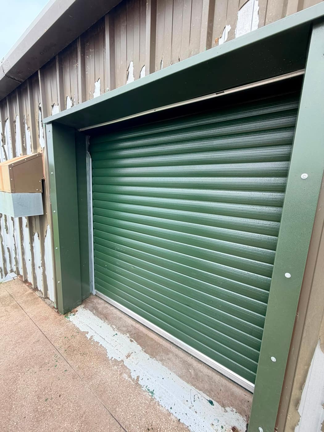 Green roller shutter fitted to a storage unit