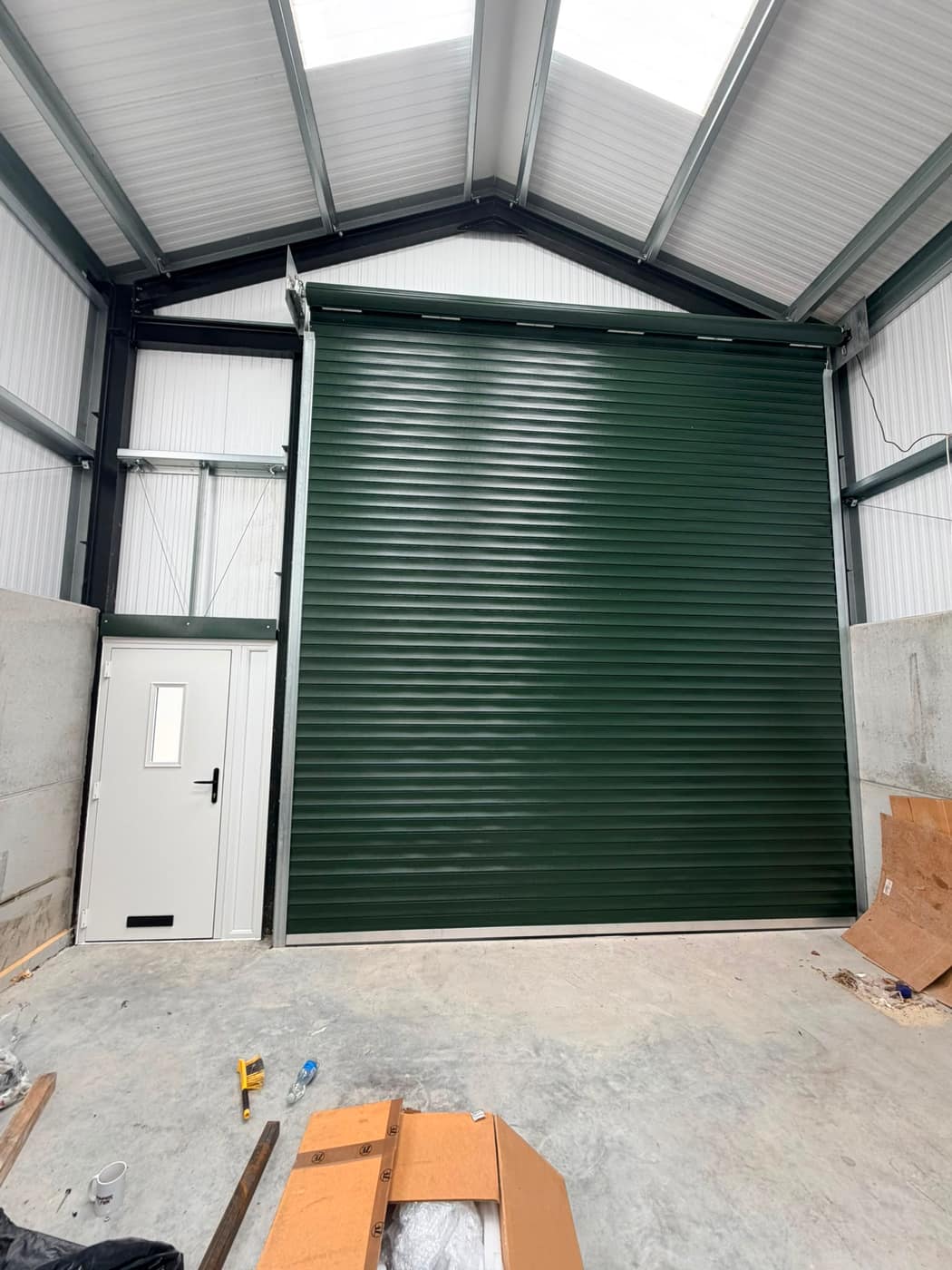 Green industrial roller shutter inside a steel workshop unit