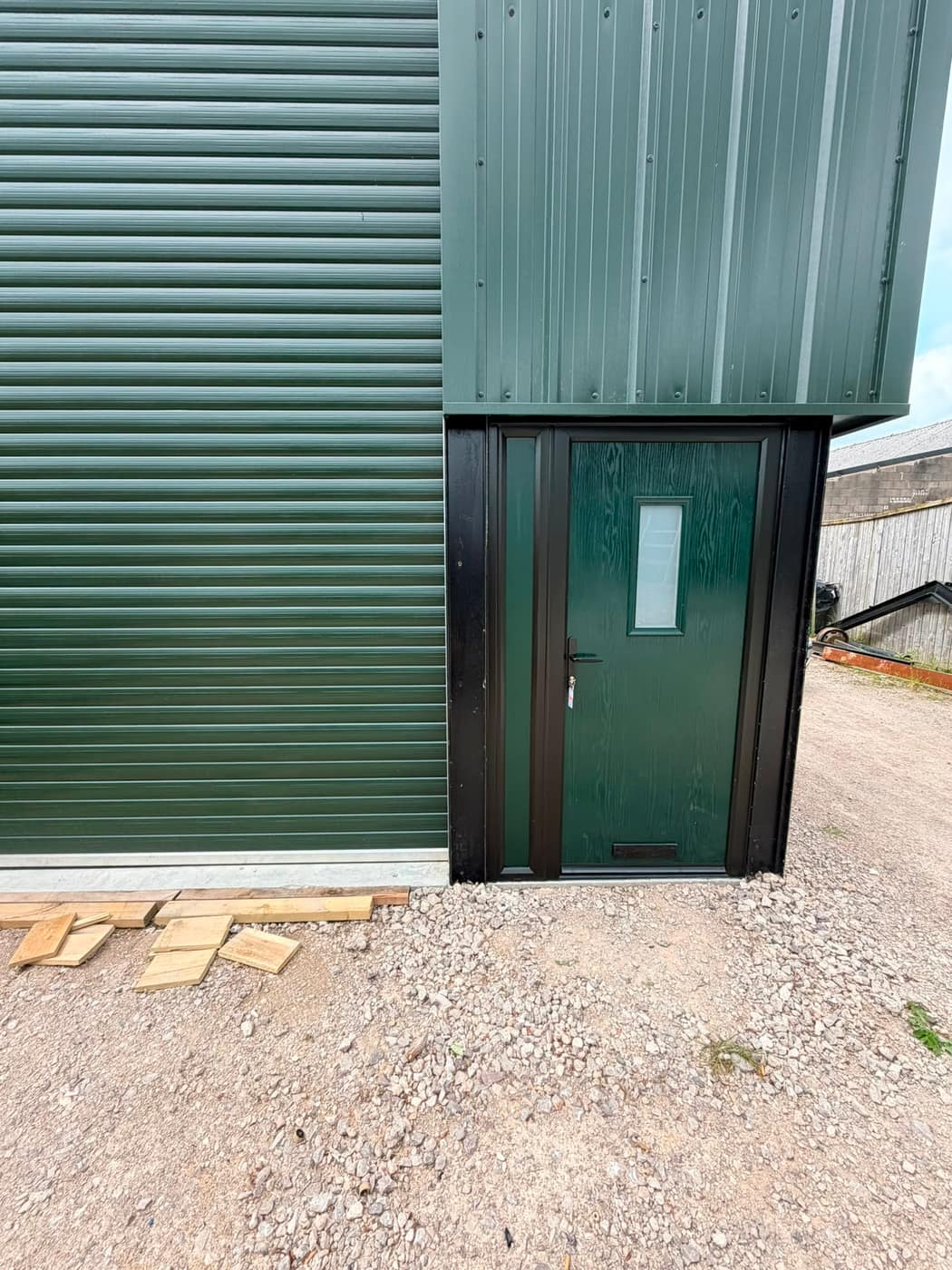 Green composite security personnel door on an industrial unit