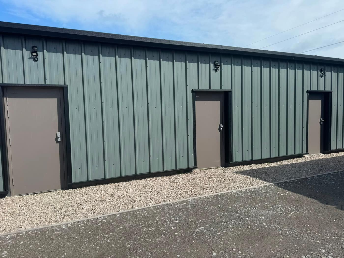 Steel personnel doors fitted to a green-clad industrial unit