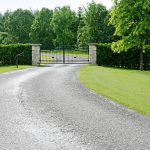 Automated sliding driveway gate between stone pillars