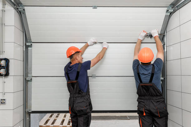 Fitters installing a white sectional industrial door