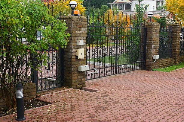 Wrought iron vehicle and pedestrian gates on brick pillars