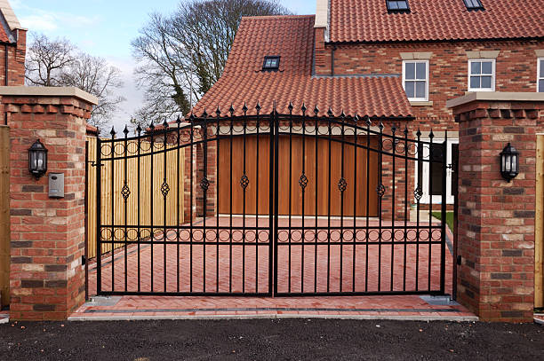 Black wrought iron double driveway gates outside a home