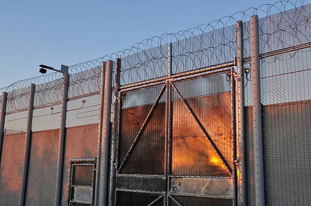 Palisade security gate with razor-wire topped fencing